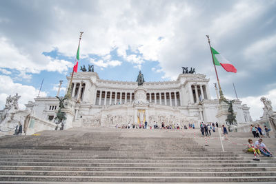 Group of people in front of historical building against sky