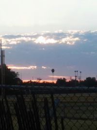 Fence on landscape at sunset