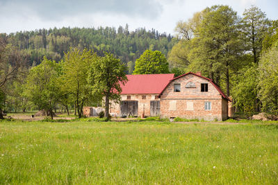 Houses by trees against sky