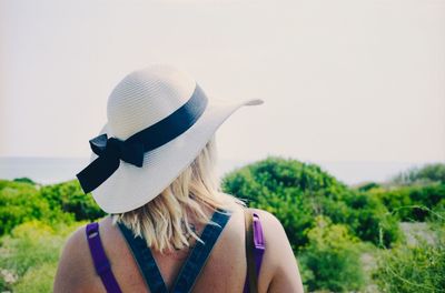 Rear view of woman against hat against clear sky