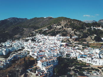 High angle view of residential district against clear blue sky