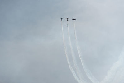 Low angle view of airplanes flying against sky during air show