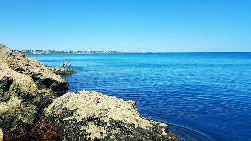 Scenic view of sea against clear blue sky