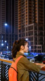 Side view of young woman looking away at night