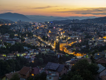 High angle view of illuminated townscape against sky at sunset