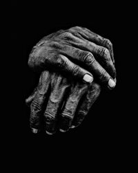 Close-up of human hand against black background