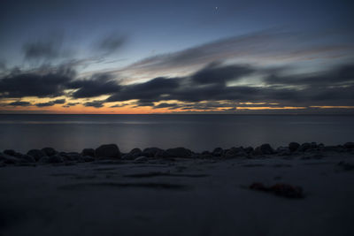 Scenic view of sea against dramatic sky during sunset