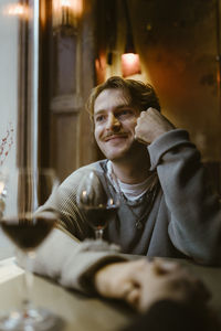 Smiling gay man on date with boyfriend at restaurant