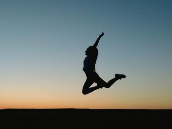 Silhouette man jumping against clear sky