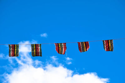 Low angle view of clothes drying against blue sky