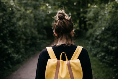 Rear view of woman standing against tree