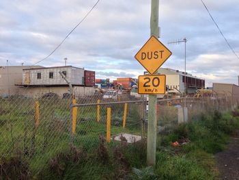 Road sign against cloudy sky