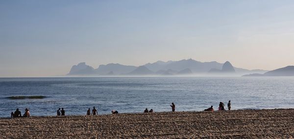 People on beach against clear sky