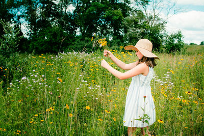 Woman holding umbrella standing on field