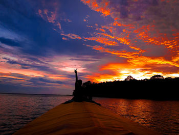 Enjoy the beautiful sunset with the hand two fingers up