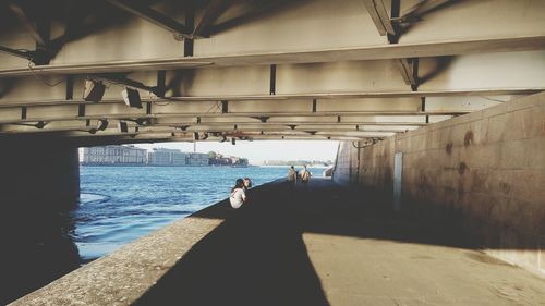 People on bridge over sea