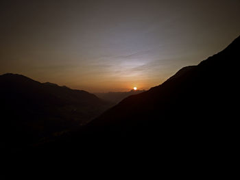 Scenic view of silhouette mountains against sky at sunset