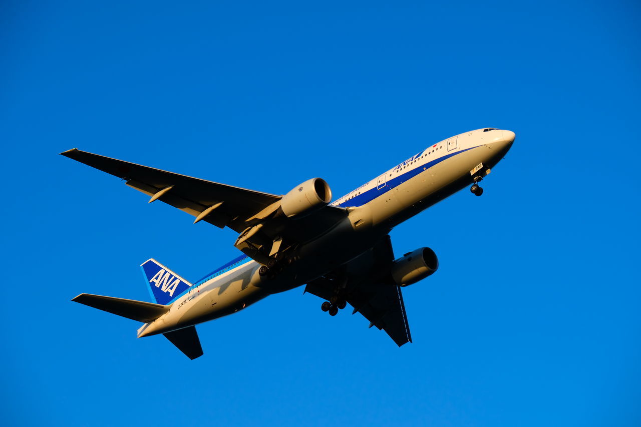 air vehicle, airplane, blue, flying, sky, mode of transportation, motion, transportation, mid-air, on the move, clear sky, low angle view, no people, nature, travel, copy space, day, public transportation, outdoors, sunlight, plane, aerospace industry, aerobatics