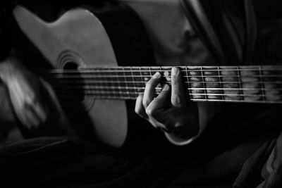 Midsection of man playing guitar