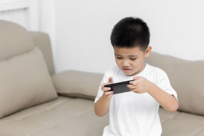 Boy using mobile phone at home