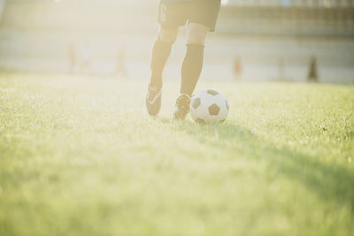 Low section of person playing soccer on field
