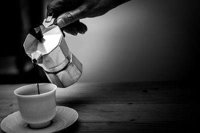 Hand holding coffee cup on table