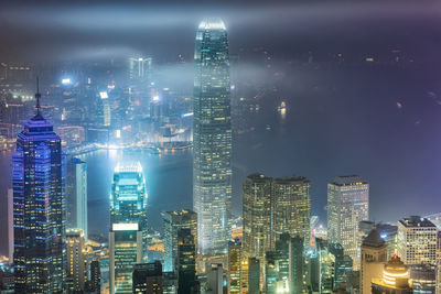 Illuminated buildings in city against sky at night