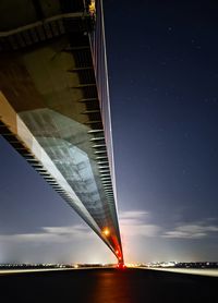 Low angle view of illuminated bridge against sky at night