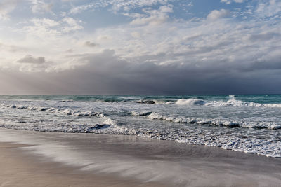 Dramatic scenic seascape. waves, cloudy sky, sunlight. sandy beach of atlantic ocean