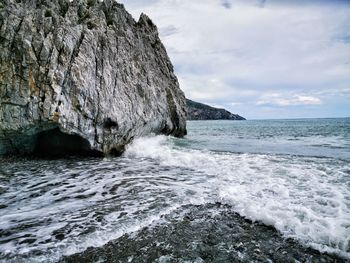 Scenic view of rocks in sea against sky