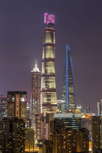 Illuminated buildings against sky at night