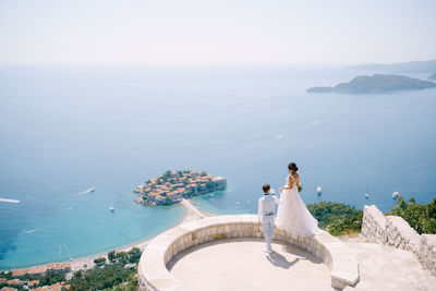 High angle view of people looking at sea against sky