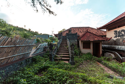 Houses by building against sky