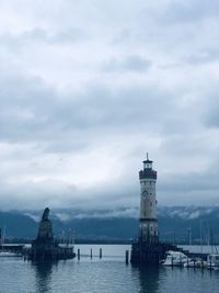 Lighthouse by sea against sky