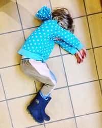 High angle view of girl wearing shoes on tiled floor
