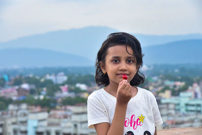 Portrait of girl standing against cityscape