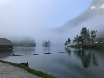 Scenic view of lake against sky during foggy weather