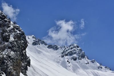 Low angle view of snowcapped mountains against sky