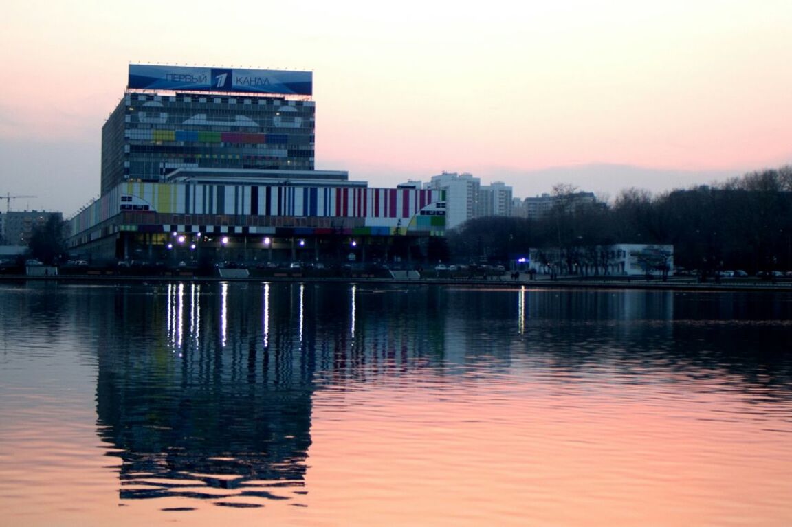 water, waterfront, architecture, built structure, building exterior, reflection, sunset, river, mid distance, dusk, clear sky, cloud, illuminated, sky, calm, outdoors, nature, no people, riverbank, scenics, tranquility, tall, water surface, tranquil scene, sea