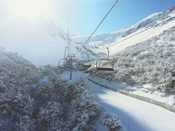 Ski lift against snowcapped mountains