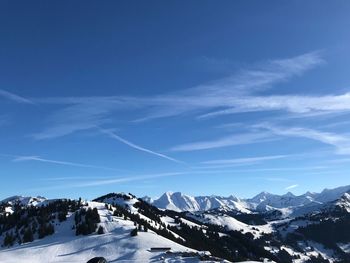 Scenic view of snowcapped mountains against blue sky