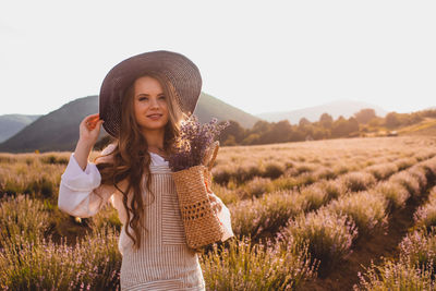 Portrait of woman standing on field against sky