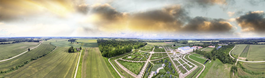 Panoramic view of road amidst field against sky