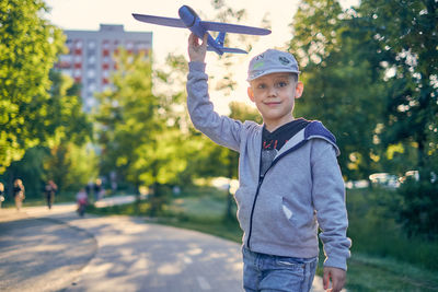 Portrait of boy holding umbrella in park