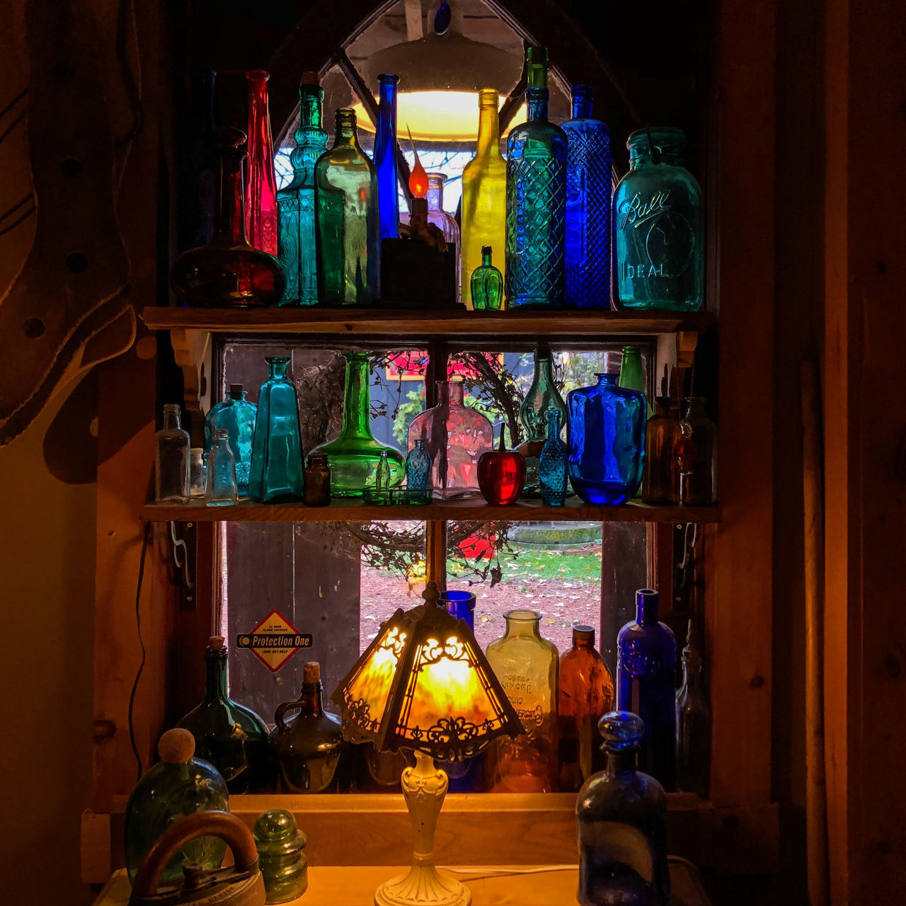 CLOSE-UP OF MULTI COLORED BOTTLES ON SHELF