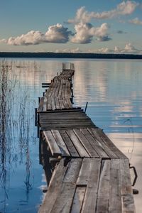 Wooden pier on lake against sky