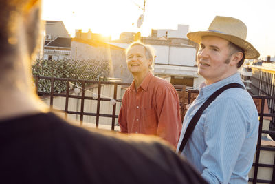 Portrait of smiling man standing against railing