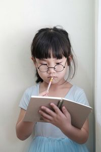 Portrait of woman standing against wall