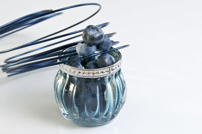 Close-up of glass jar on table against white background
