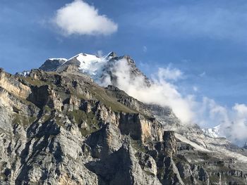 Low angle view of snowcapped mountains against sky